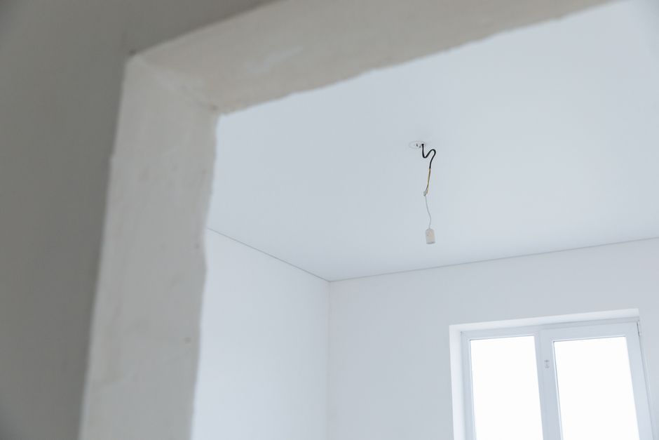 Svijetla bijela prostorija s otvorenim električnim instalacijama i prirodnim svjetlom
